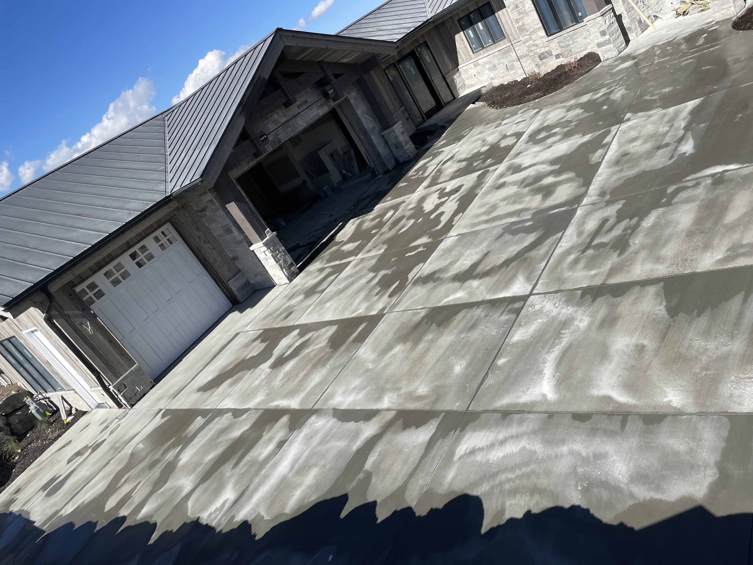 unfinished-concrete-driveway-house-in-background-scaled